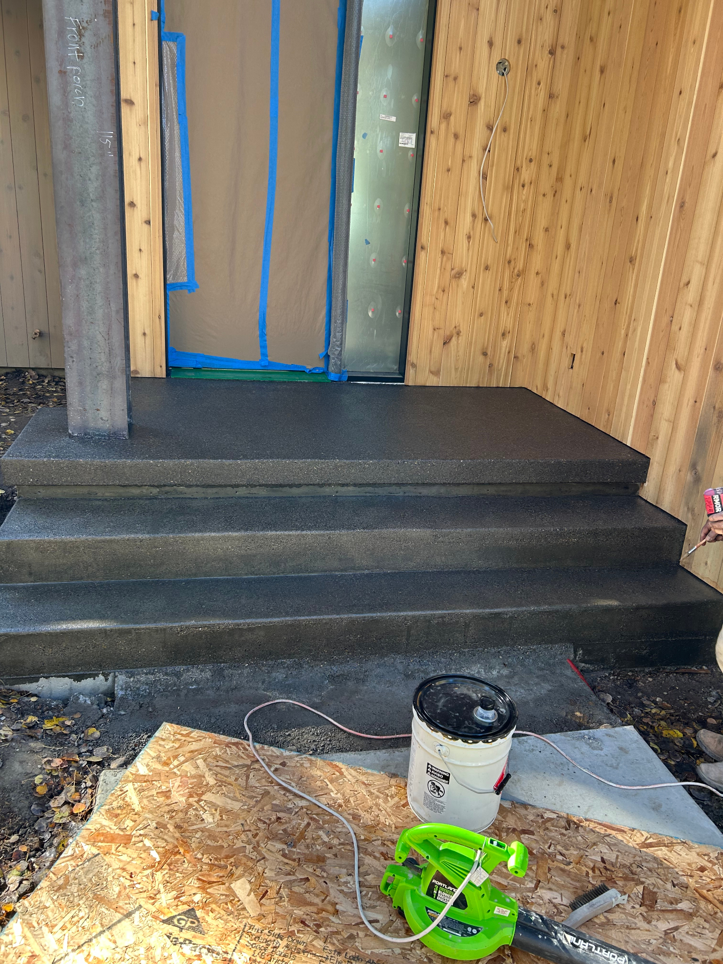 Charcoal stained concrete front porch and steps with cedar siding