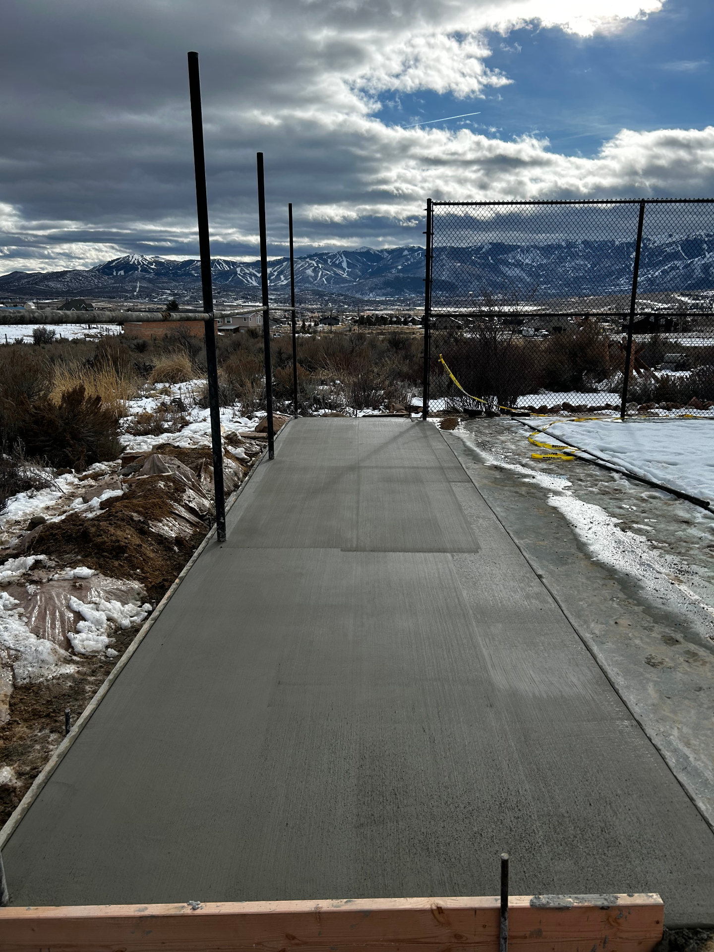 Concrete walkway alongside batting cage with Park City mountain views