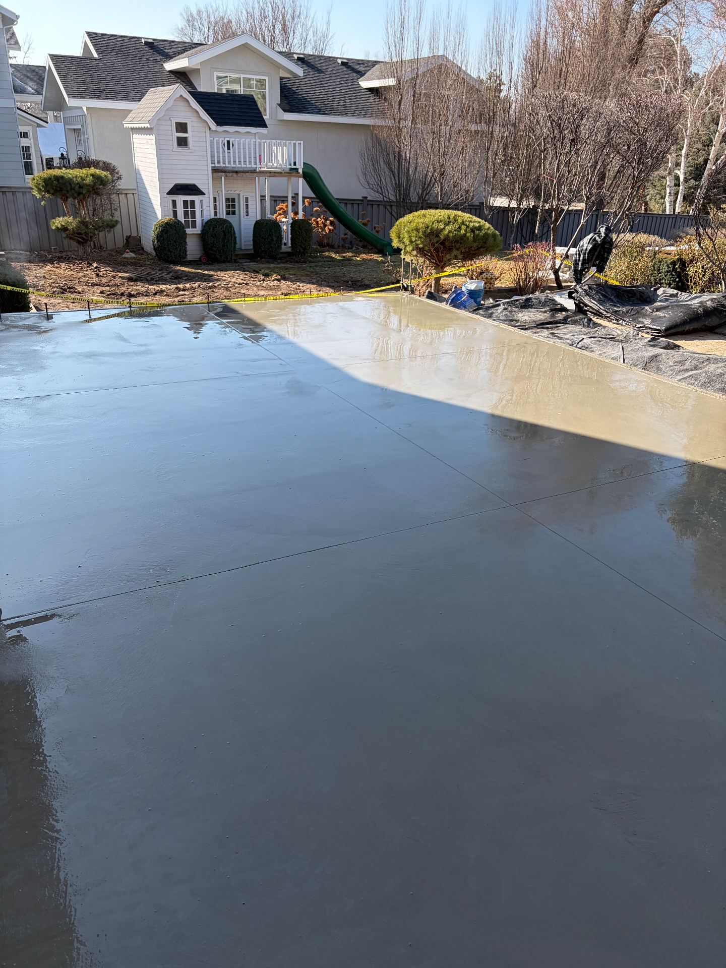 Large freshly finished backyard concrete patio in residential neighborhood